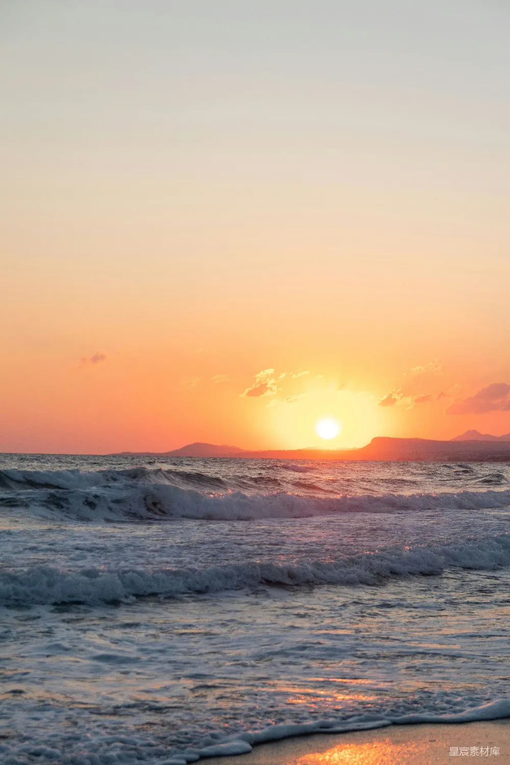 高清摄影 海滩上的太阳正落下海平线。