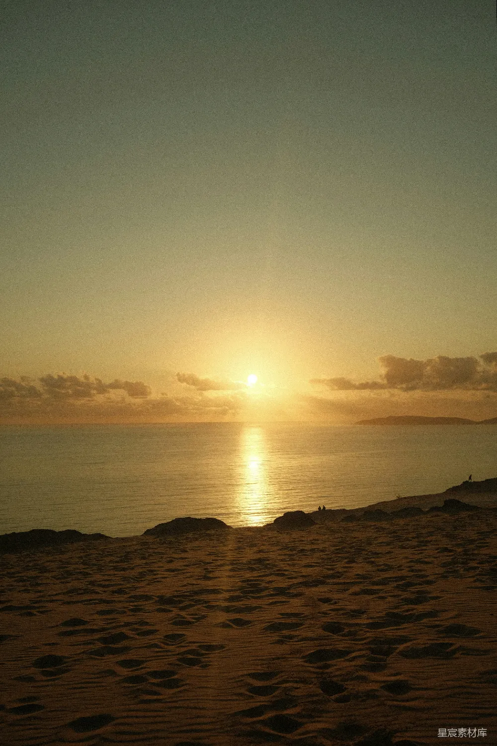 高清摄影 海滩上的太阳正落在海面上。