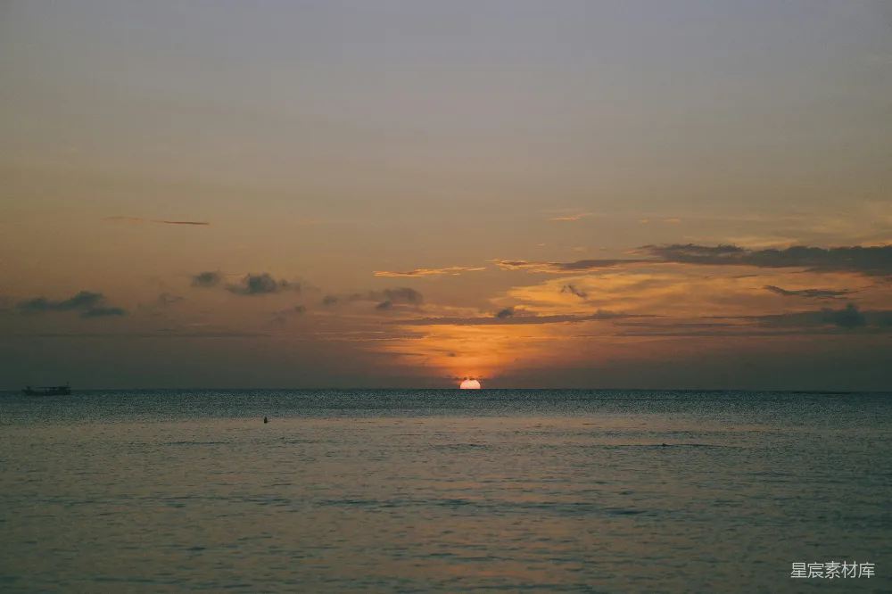 高清摄影 夕阳西下，海天相连处有一叶扁舟。