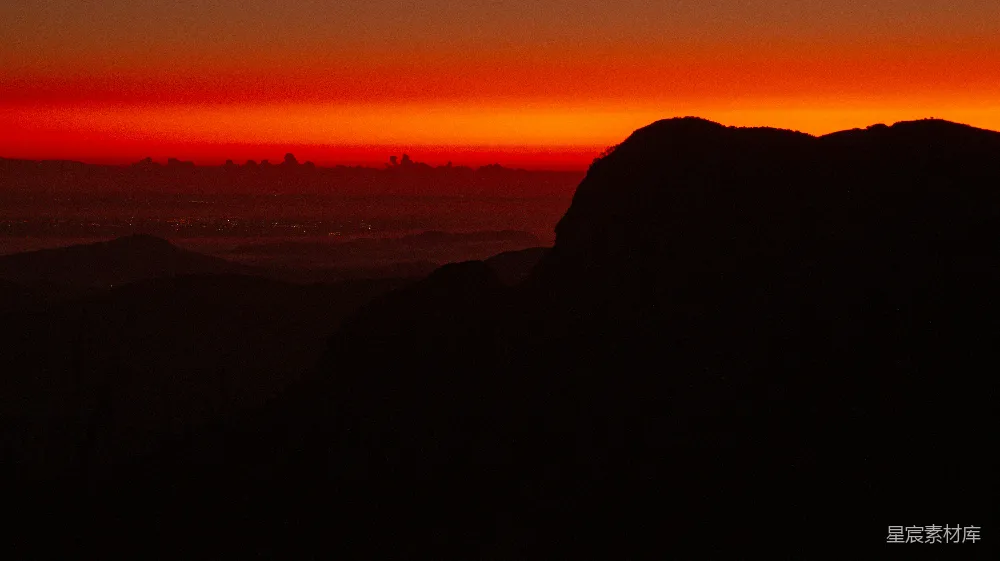 高清摄影 夕阳西下，落日余晖洒在连绵的山峦之上。