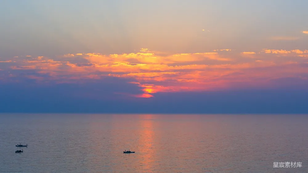 高清摄影  夕阳下的平静海面与小船