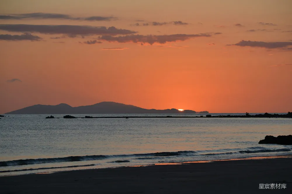 高清摄影 天边太阳正在落下，远处是山峦。