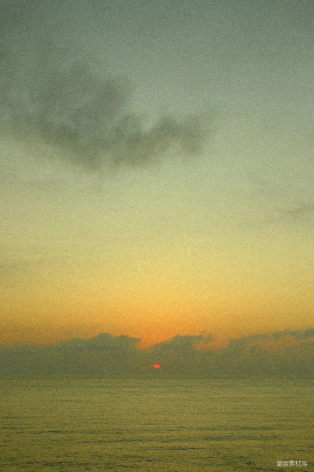 高清摄影 一天中的夕阳正在海边的云层中落下。