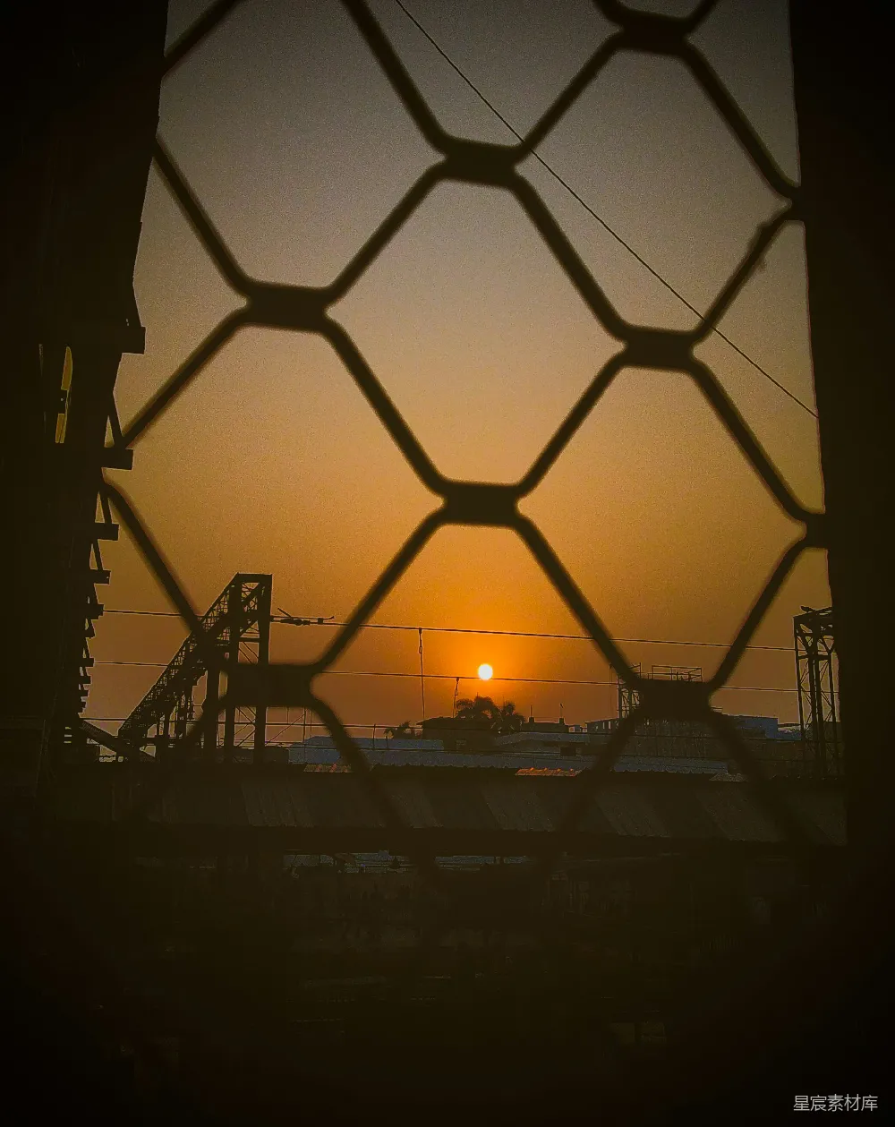 高清摄影 夕阳落在一道铁丝网后面