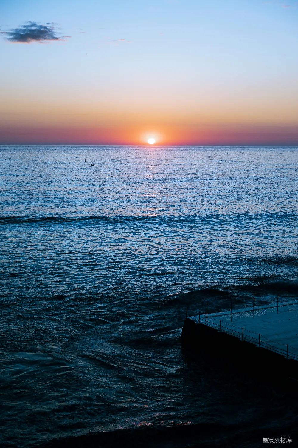 高清摄影 夕阳西下，海平面上有一座码头在前景。
