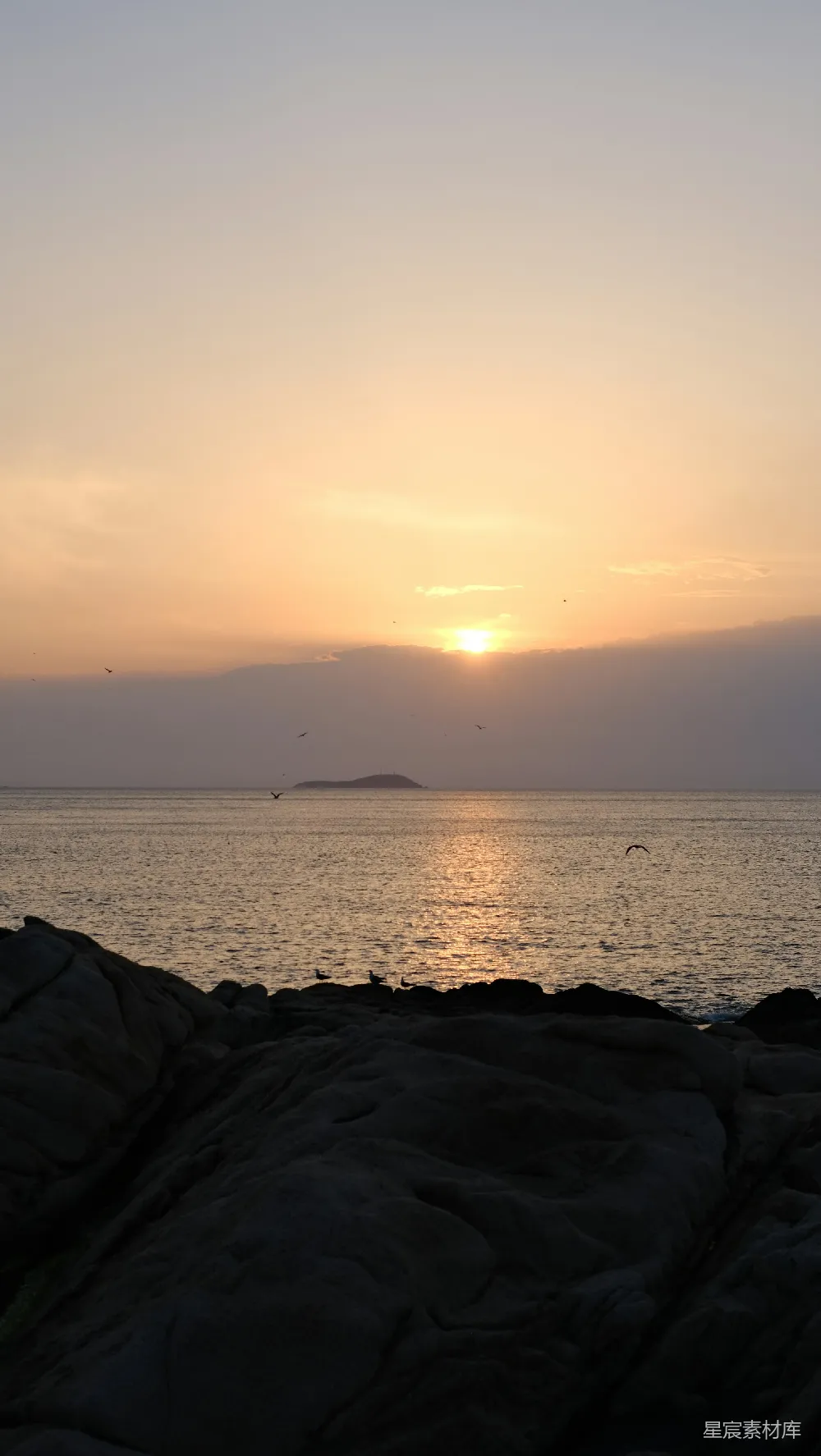 高清摄影 夕阳西下，落在海边的一片岩石上。