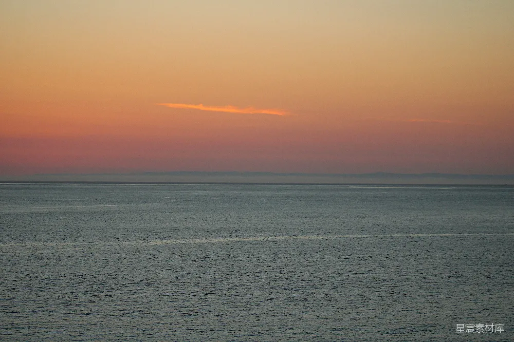 高清摄影 背景中有夕阳的一片广阔水域。