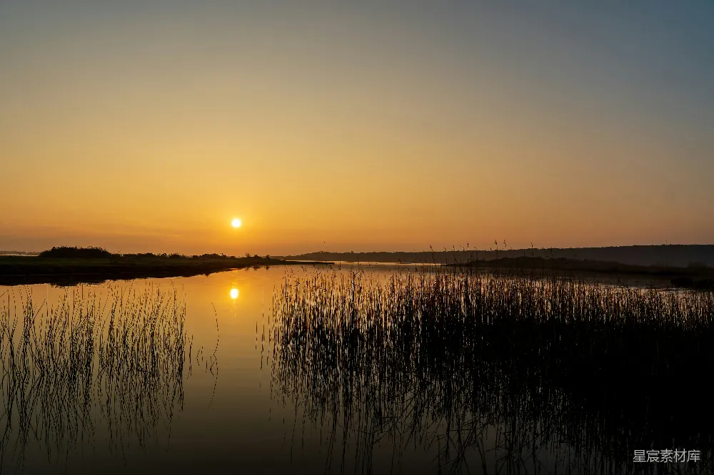 高清摄影 夕阳落下在一片水域之上