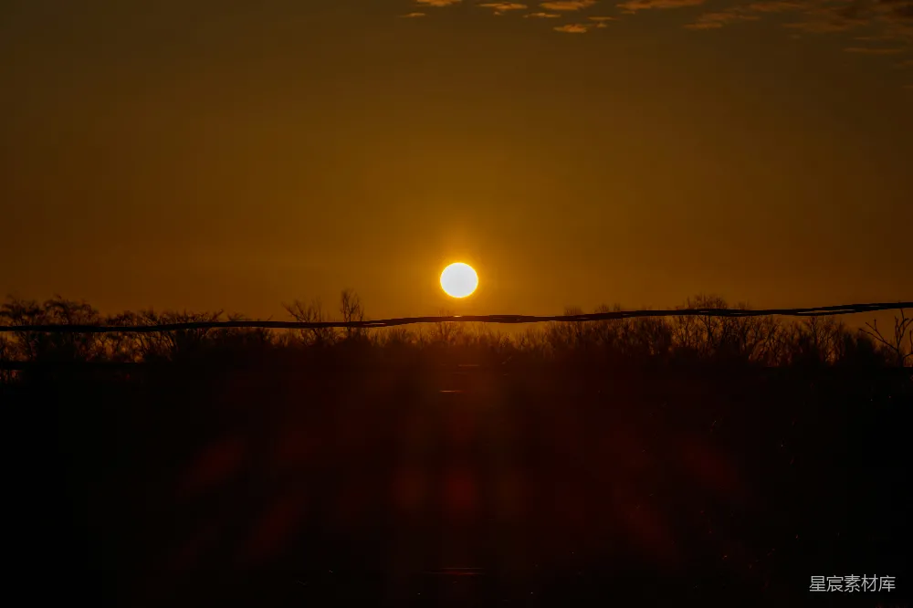 高清摄影 夕阳落在一道铁丝网围栏后面