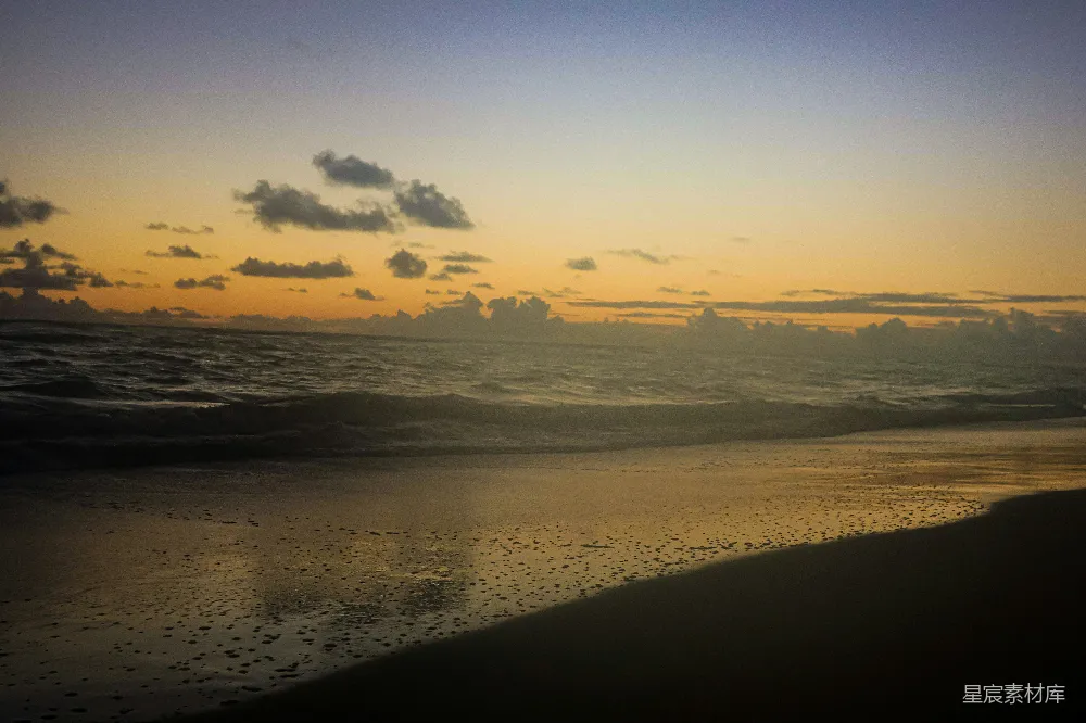 高清摄影 旅行 夕阳下的海滩，沙上倒映着水面的光芒。