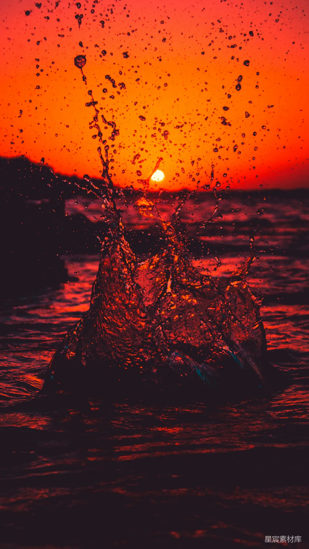 高清摄影 夕阳下黑岩上的水花溅起