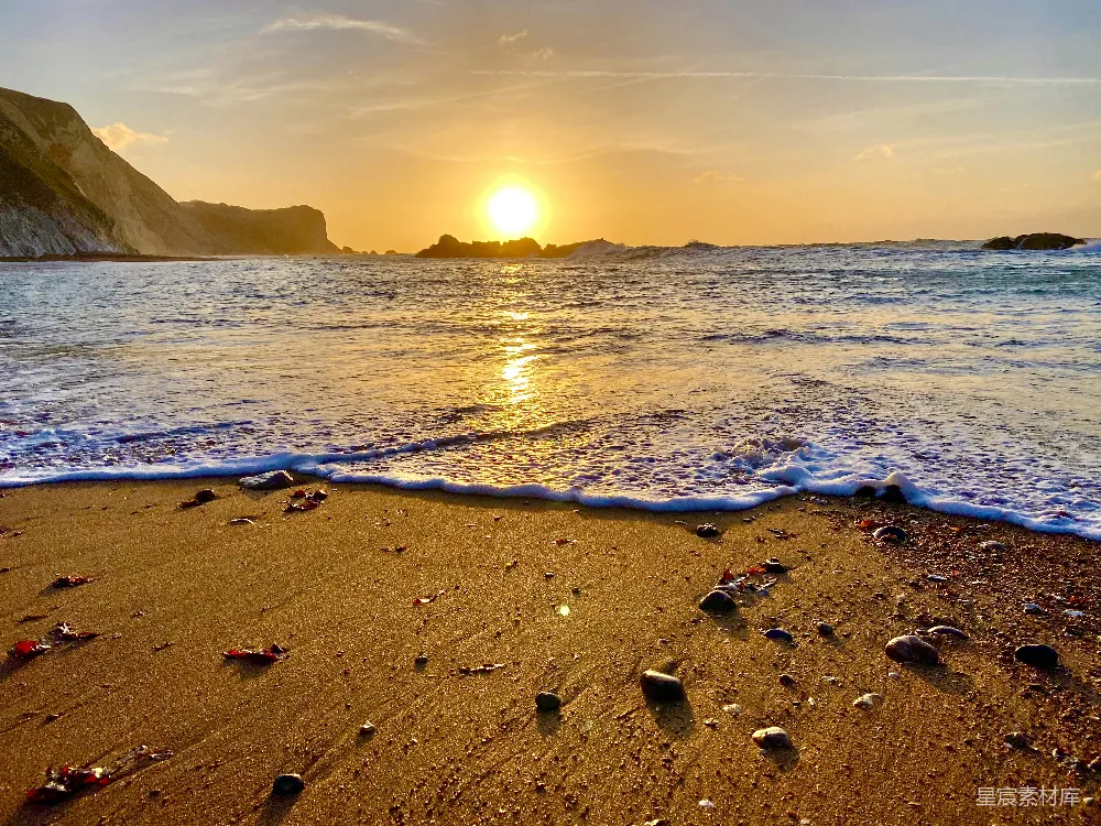 高清摄影 海滩上的夕阳落下水面