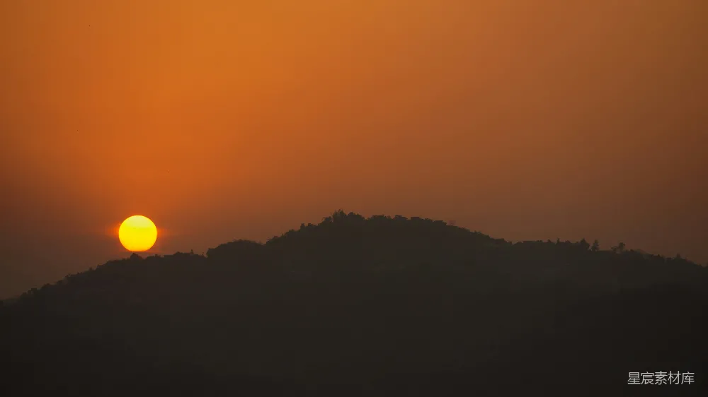高清摄影 山坡上太阳正在落下， surrounded by trees。
