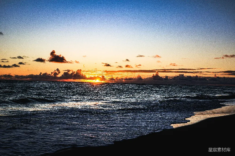 高清摄影 海浪在日落时分拍打着海滩。