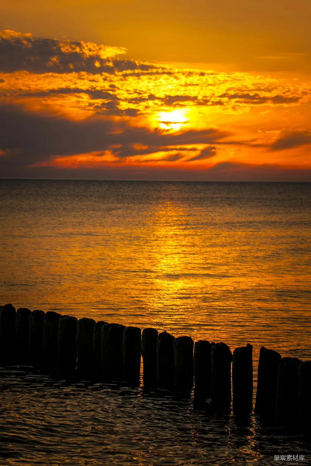 高清摄影 夕阳西下，海平面上有一座码头在 foreground。