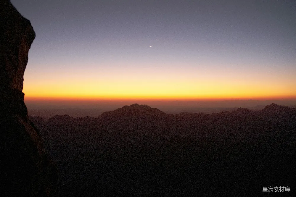 高清摄影 背景有一座山，夕阳映照在一片水面之上。