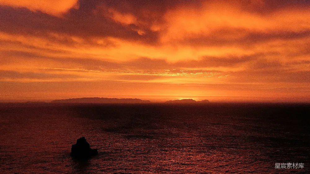 高清摄影 夕阳下两个人坐在岩石上的轮廓