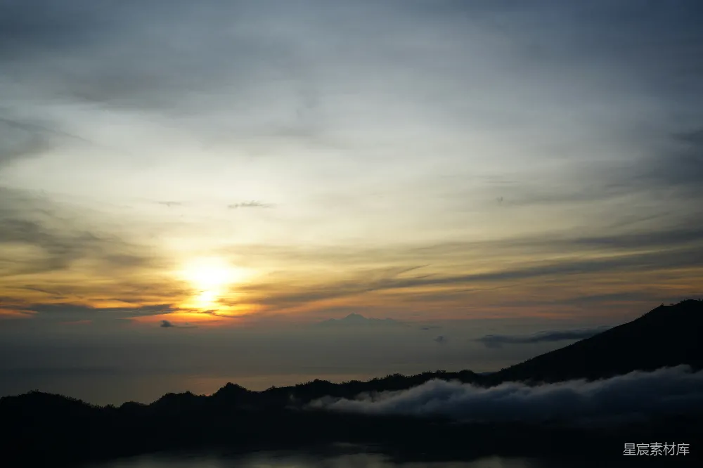 高清摄影 夕阳西下，山脚下云雾缭绕。