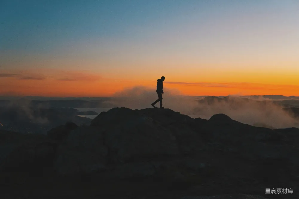高清摄影 山顶上站立着一个人在夕阳下。