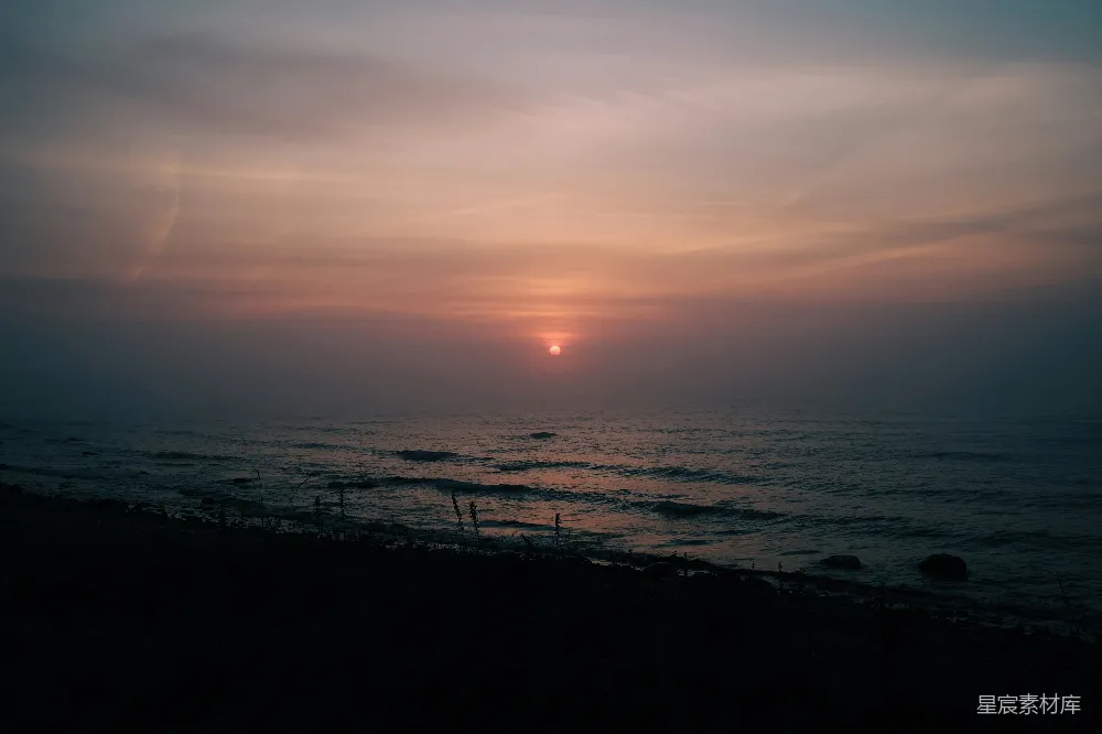 高清摄影 雾天，太阳正沉落在海面上。