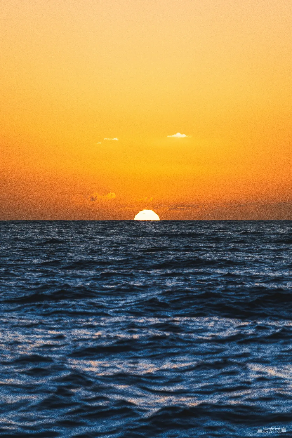 高清摄影  夕阳西下，海面上有一艘船在远处。
