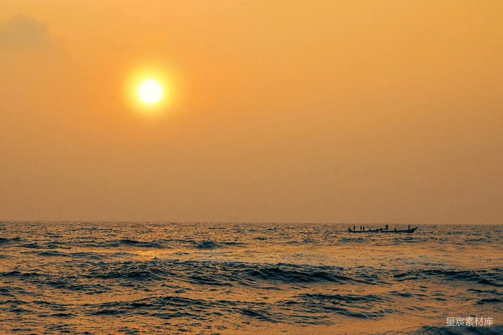 高清摄影 夕阳西下，海面上停着一条船。