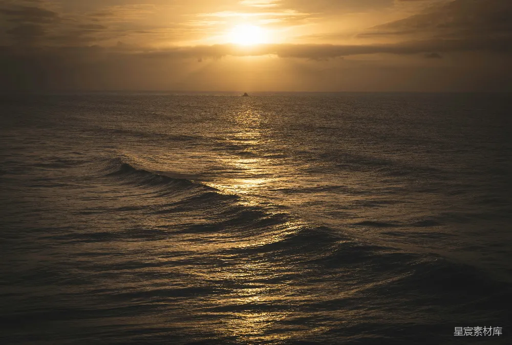 高清摄影 夕阳西下，海面上有一艘船在远处。