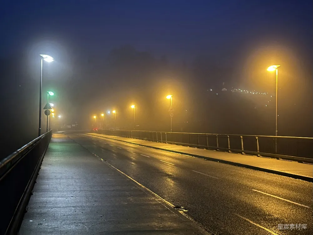 高清摄影 雾蒙蒙的夜晚在一条有路灯的道路行驶