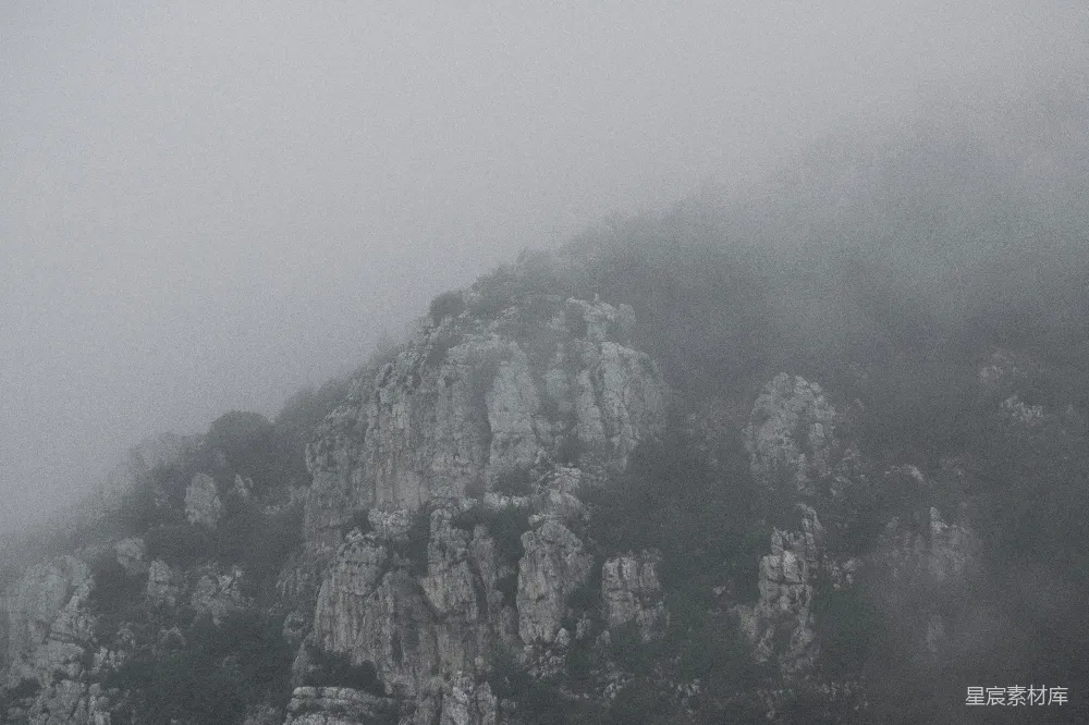 高清摄影 一座被雾和低垂的云层覆盖的山峰