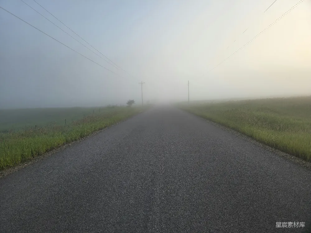 高清摄影 远处有一条雾气弥漫的道路，电线上点缀着光芒。