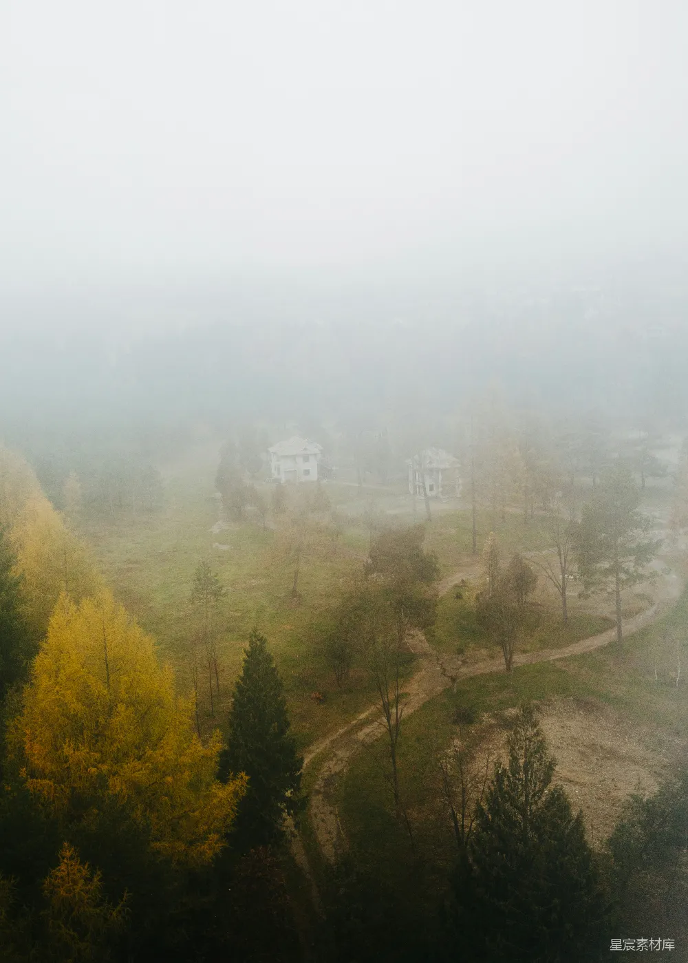高清摄影 远处有一片雾气笼罩的风景，有树木和房屋。