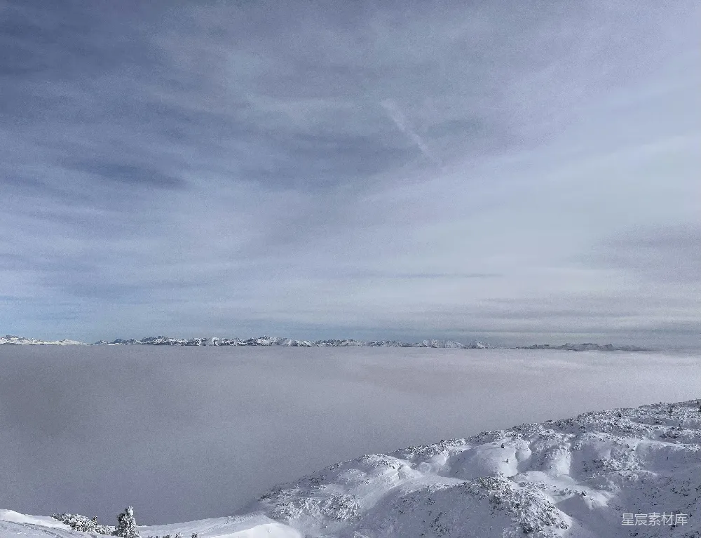 高清摄影 山顶上站立着一个人，身后覆盖着皑皑白雪。