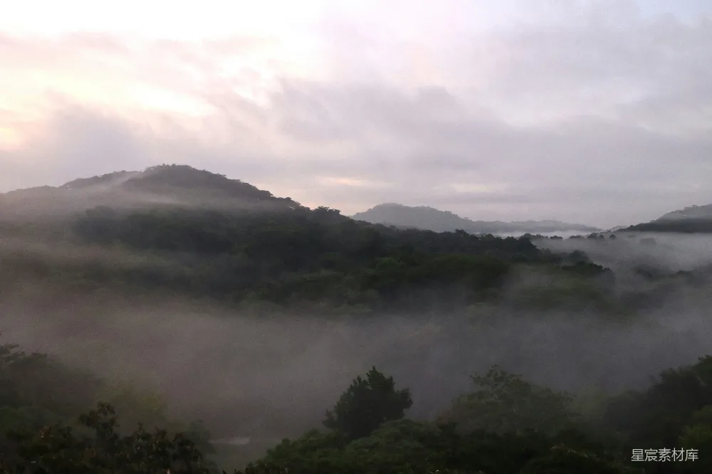 高清摄影 山间有树和丘陵的背景，一片雾气蒙蒙。