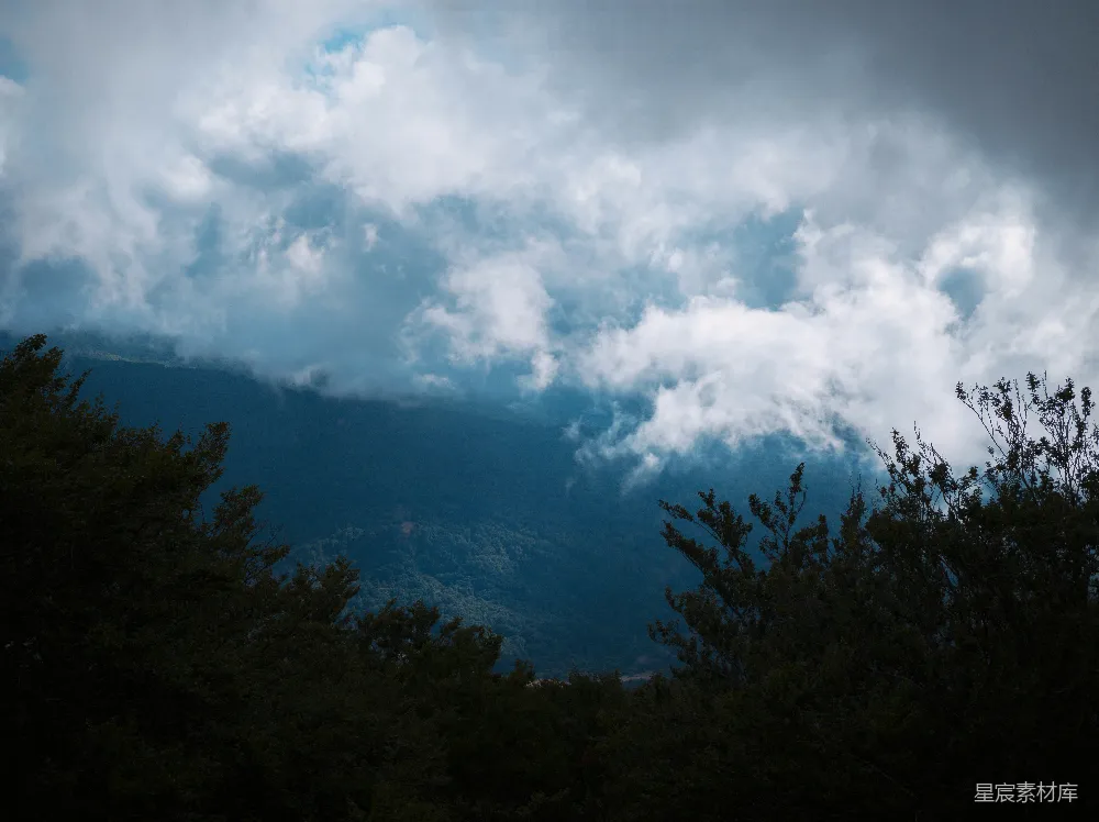 高清摄影 山林间一片阴沉，飘浮着 dramatic 的云层。