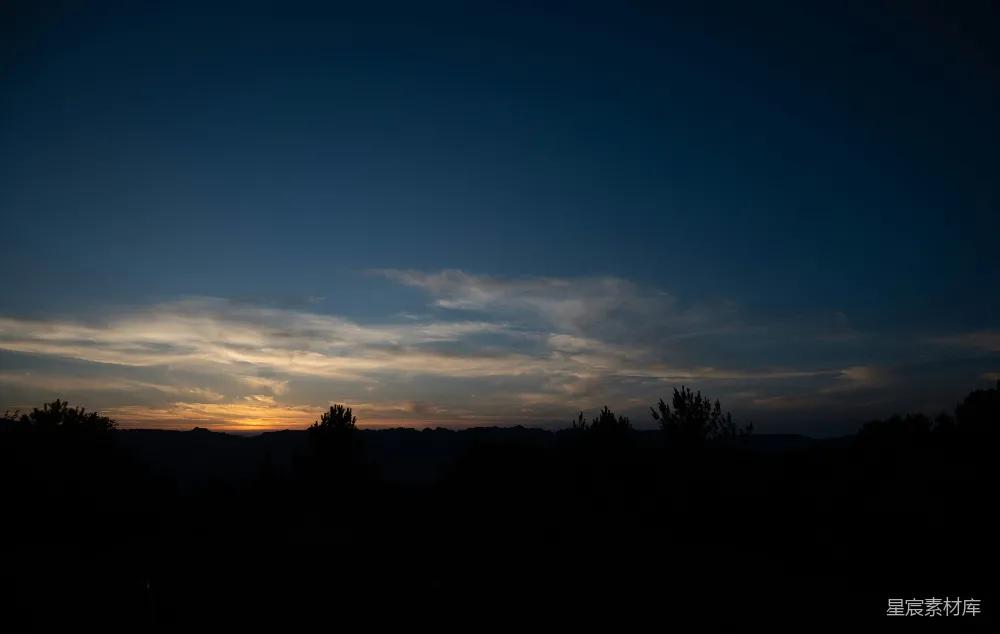高清摄影 夕阳西下，一片田地环绕着树木。