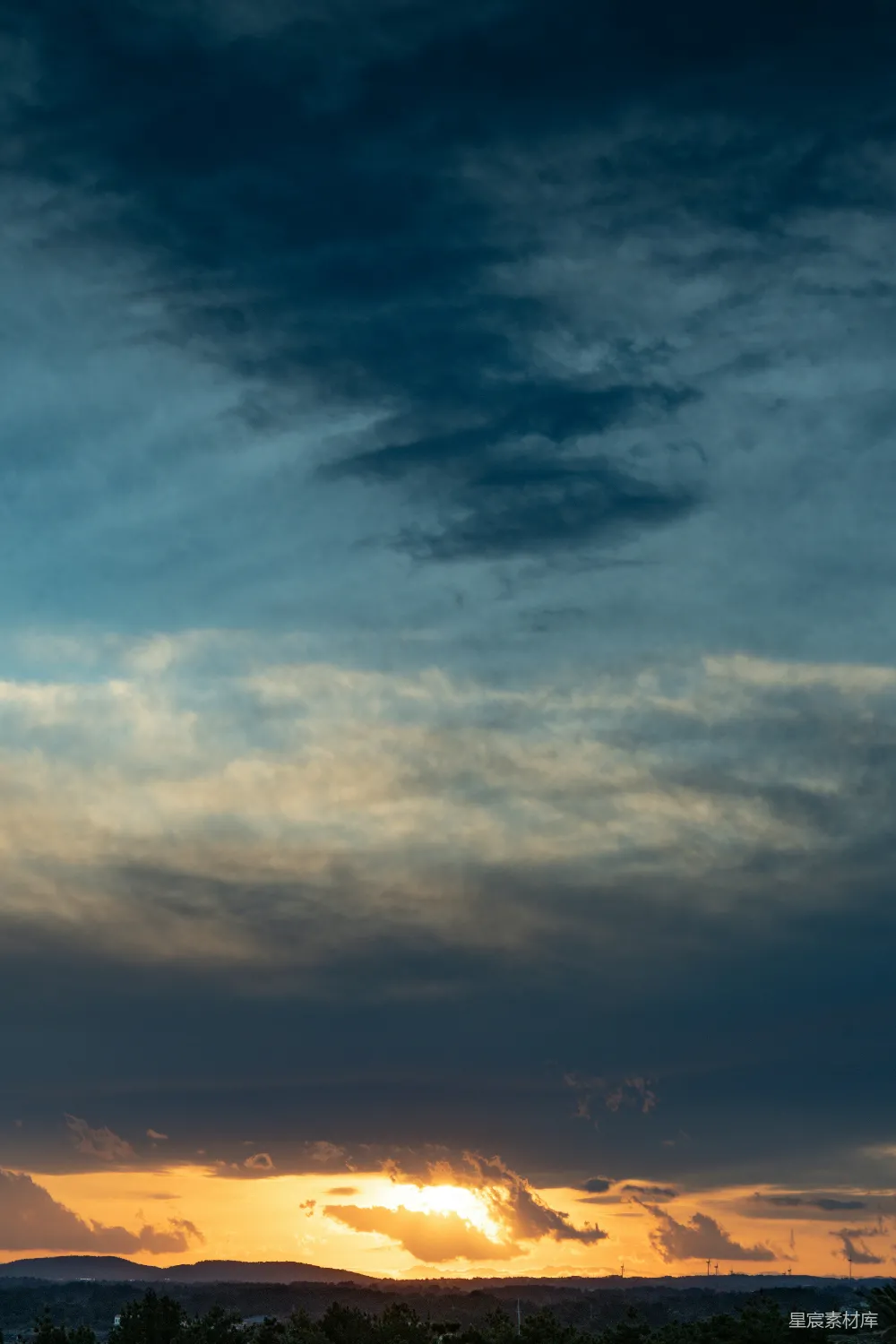 高清摄影 远处山峦的夕阳余晖中飘浮着云彩。