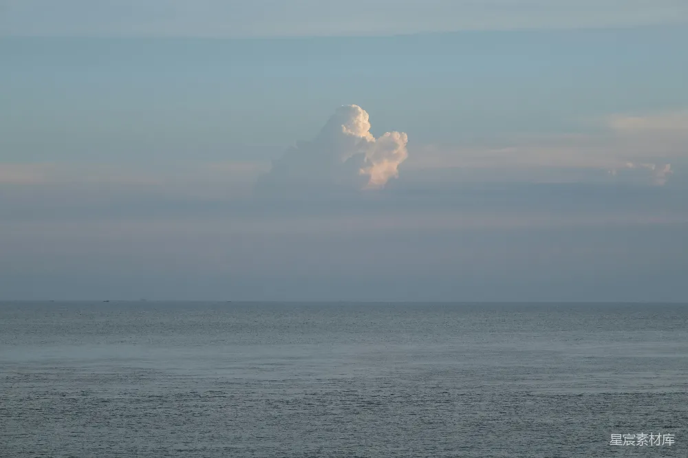 高清摄影 一片云朵漂浮在平静的海洋上。