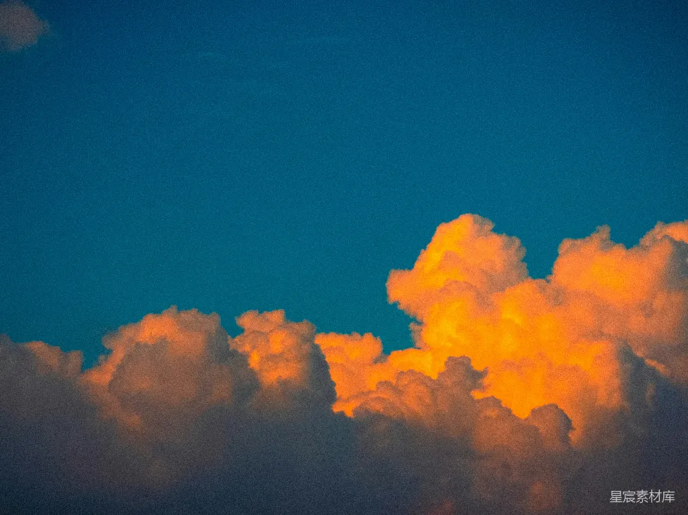高清摄影 夕阳映照下的金色云朵在蓝天上熠熠生辉。