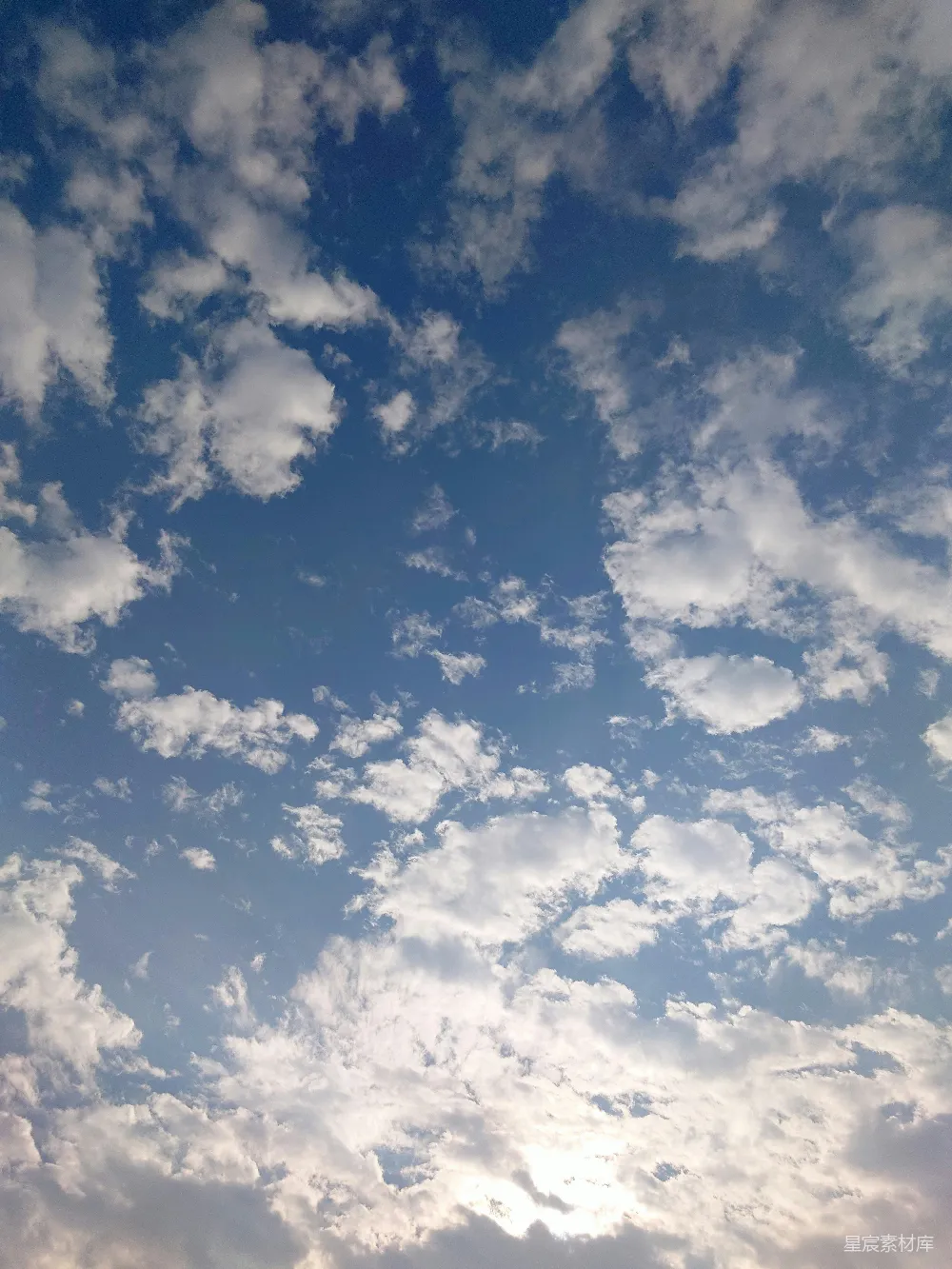 高清摄影 一架飞机在一片云层中穿越蔚蓝的天空