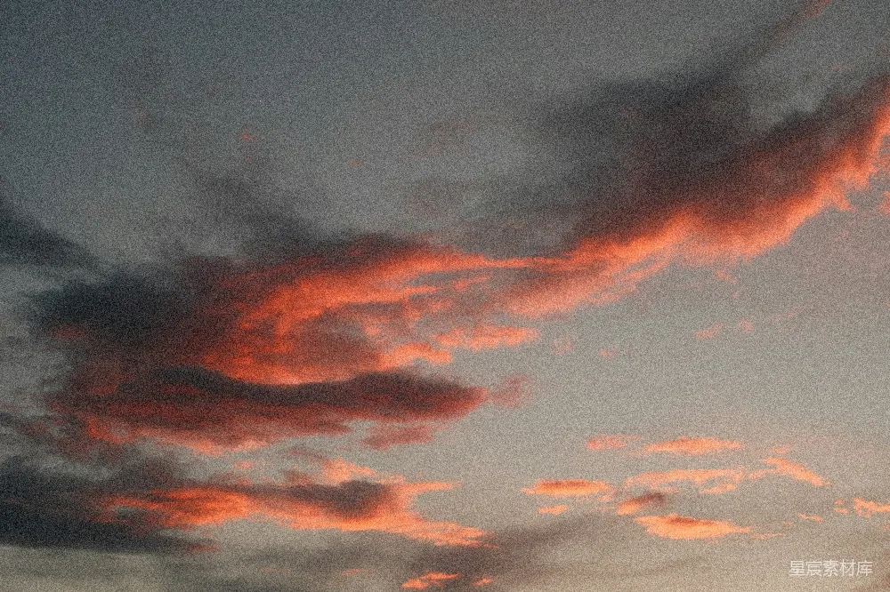 高清摄影 夕阳下红色和橙色的云朵 against 灰色的天空。