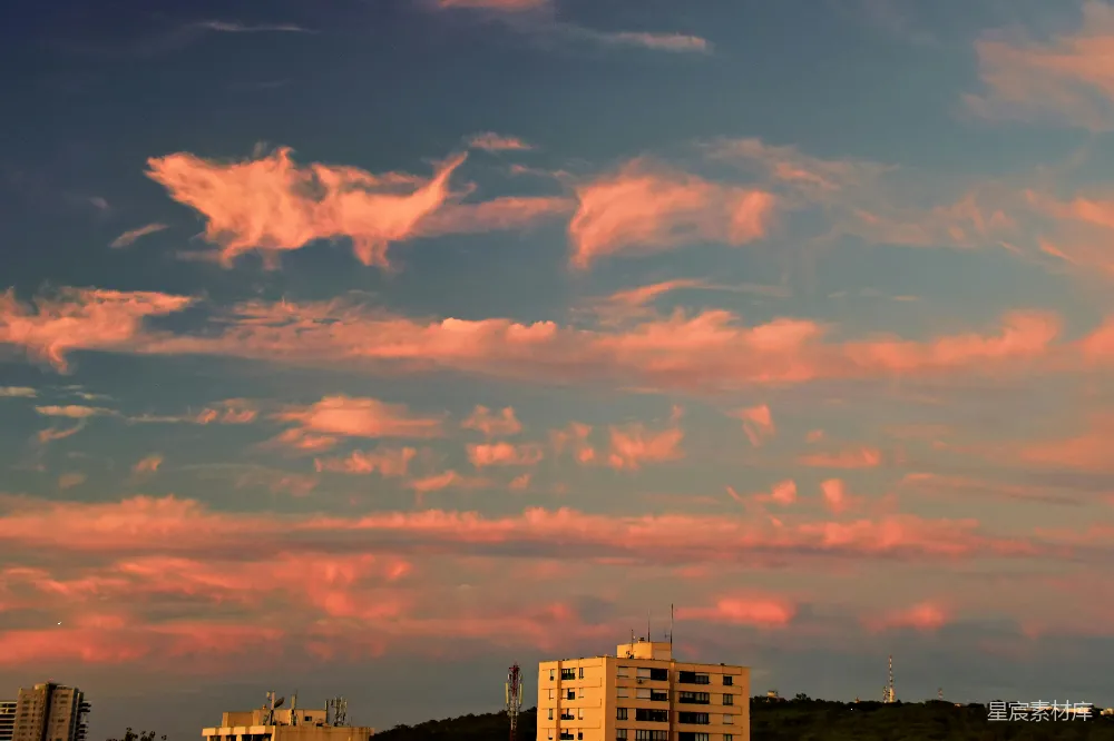 高清摄影 夕阳下，粉色的云朵在蓝天上掠过。