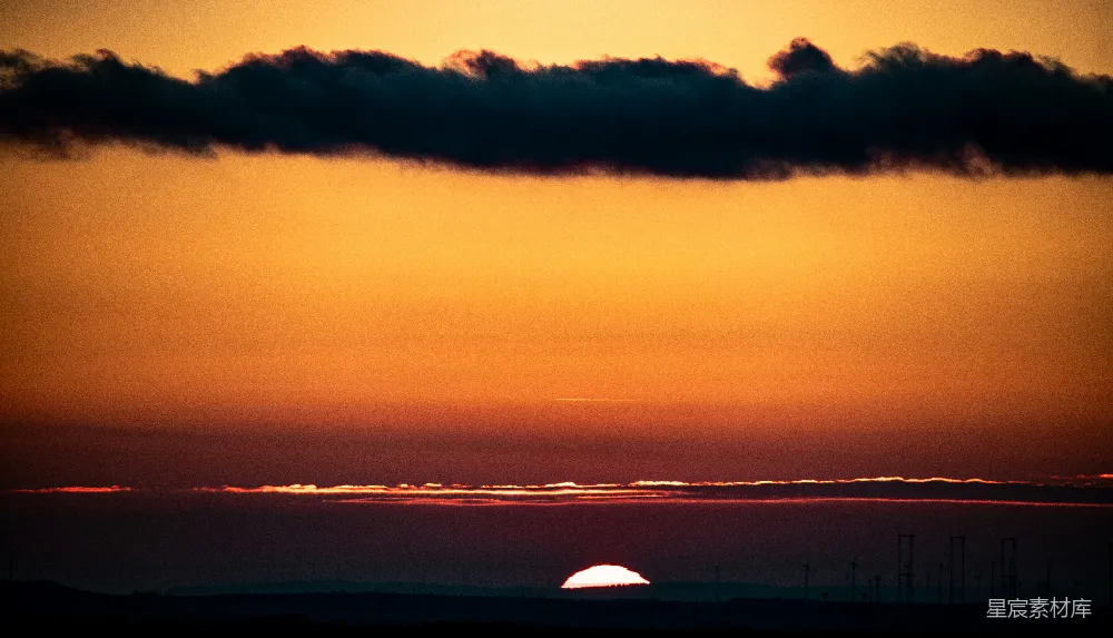 高清摄影 夕阳西下，落在一片水域的天际线上。