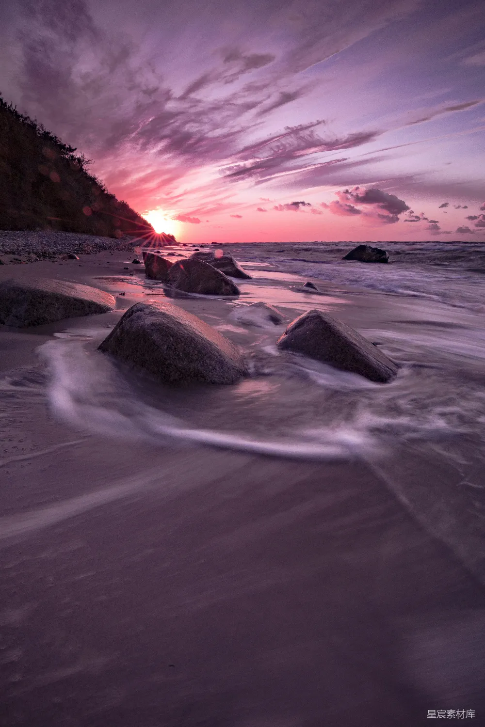 高清摄影 夕阳西下，海平面上有岩石作为前景。