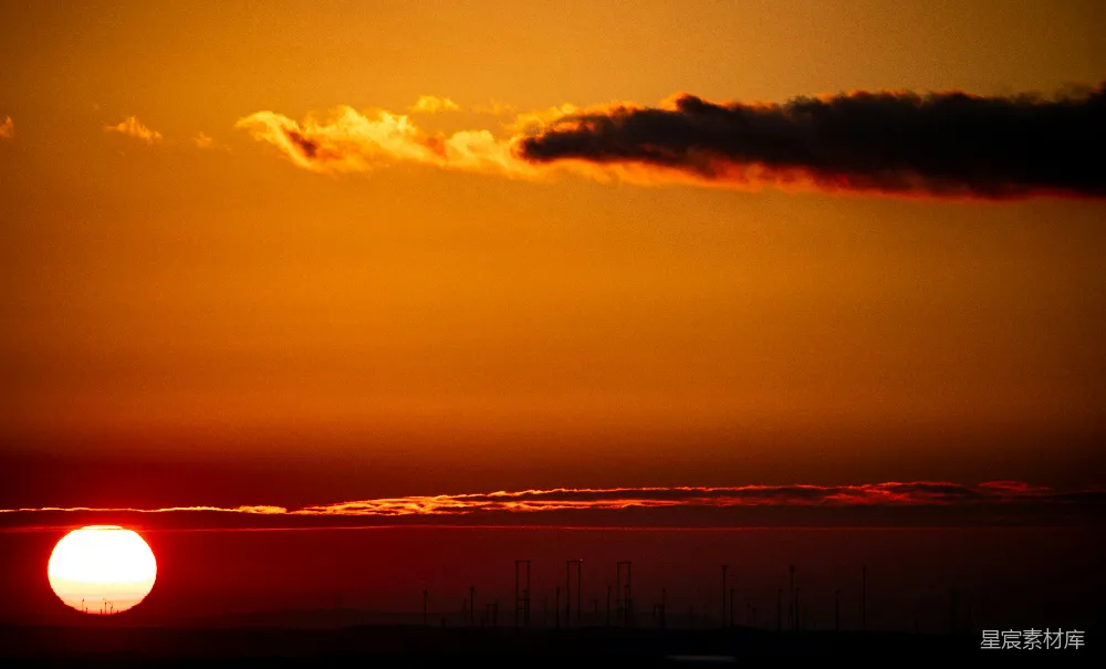 高清摄影 夕阳西下，落日余晖洒在一片水域的天际之上