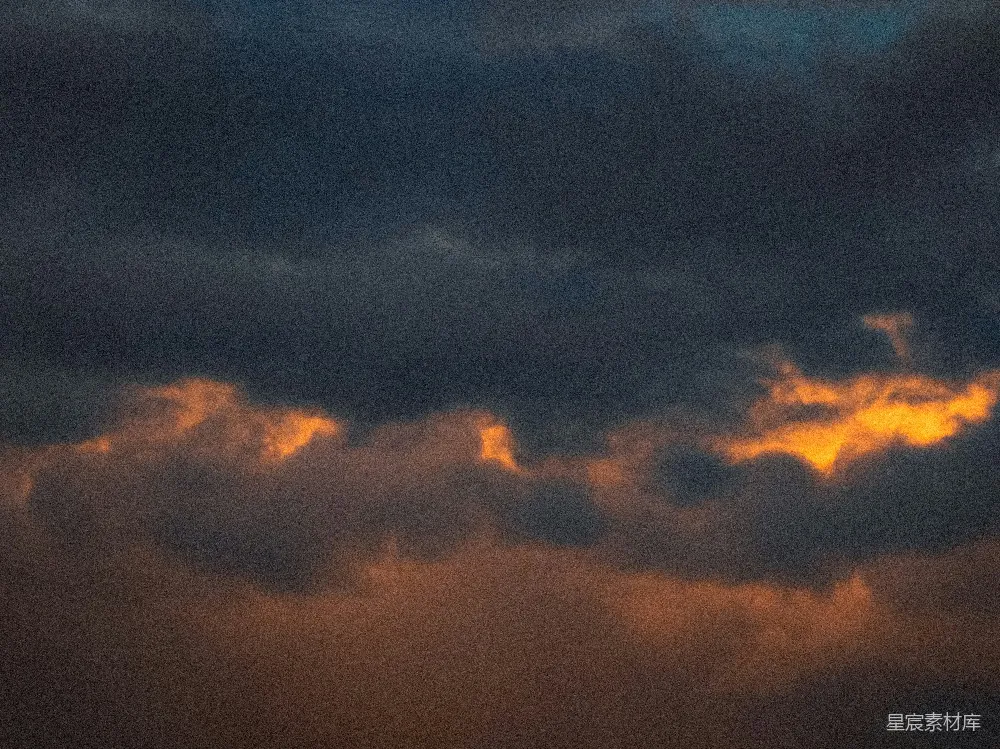 高清摄影 dramatic dark clouds illuminated by golden sunset light.