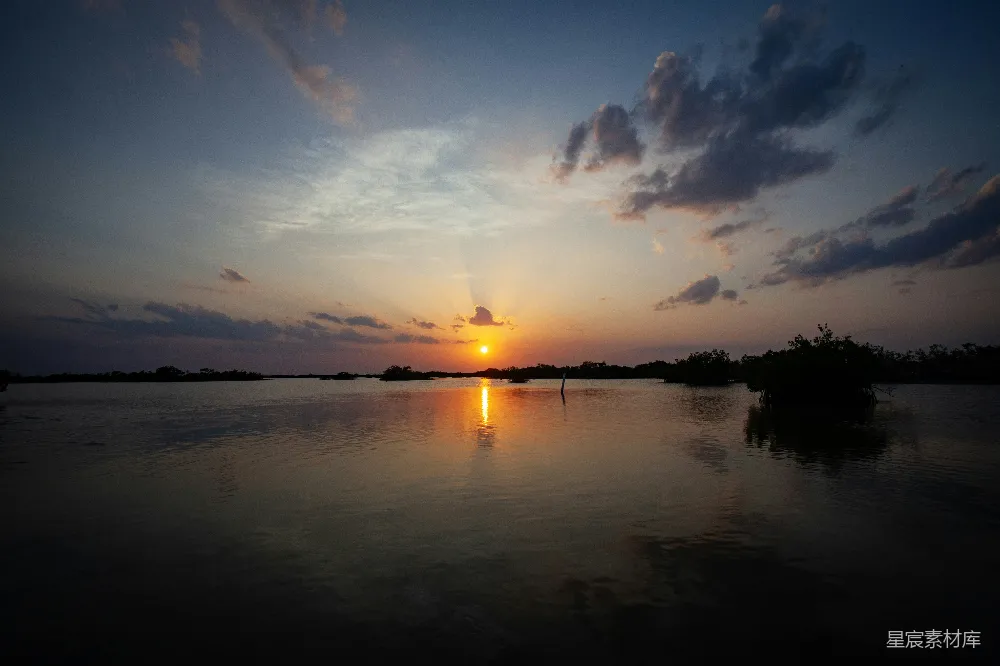 高清摄影 夕阳落下在一片水域之上