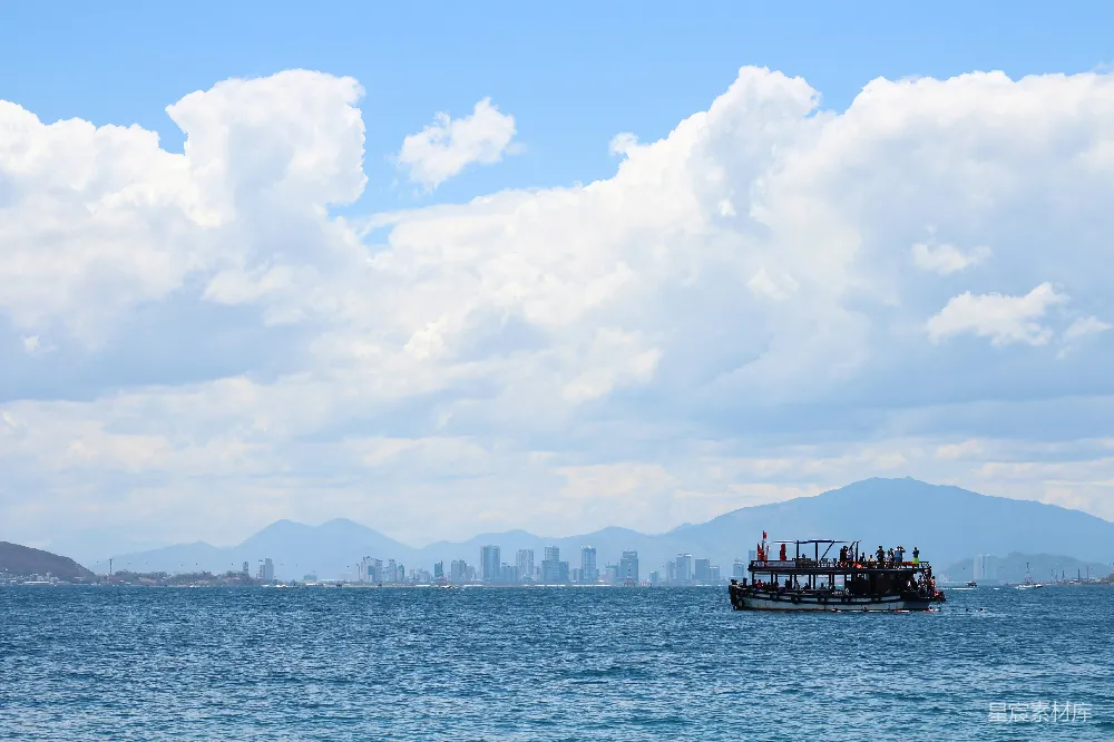 高清摄影 一艘船位于大海的中央，背景是城市。