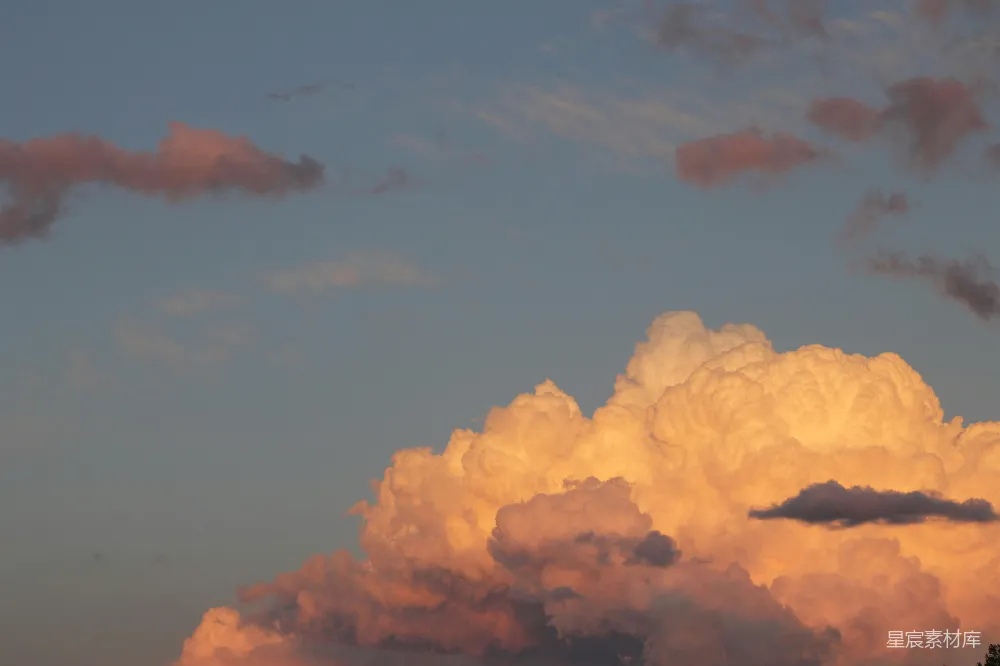 高清摄影 夕阳在天空中照亮了蓬松的云朵。