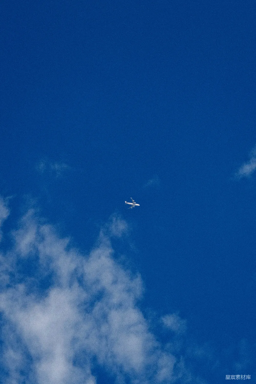 高清摄影 一架小白色飞机在湛蓝的天空中飞行。