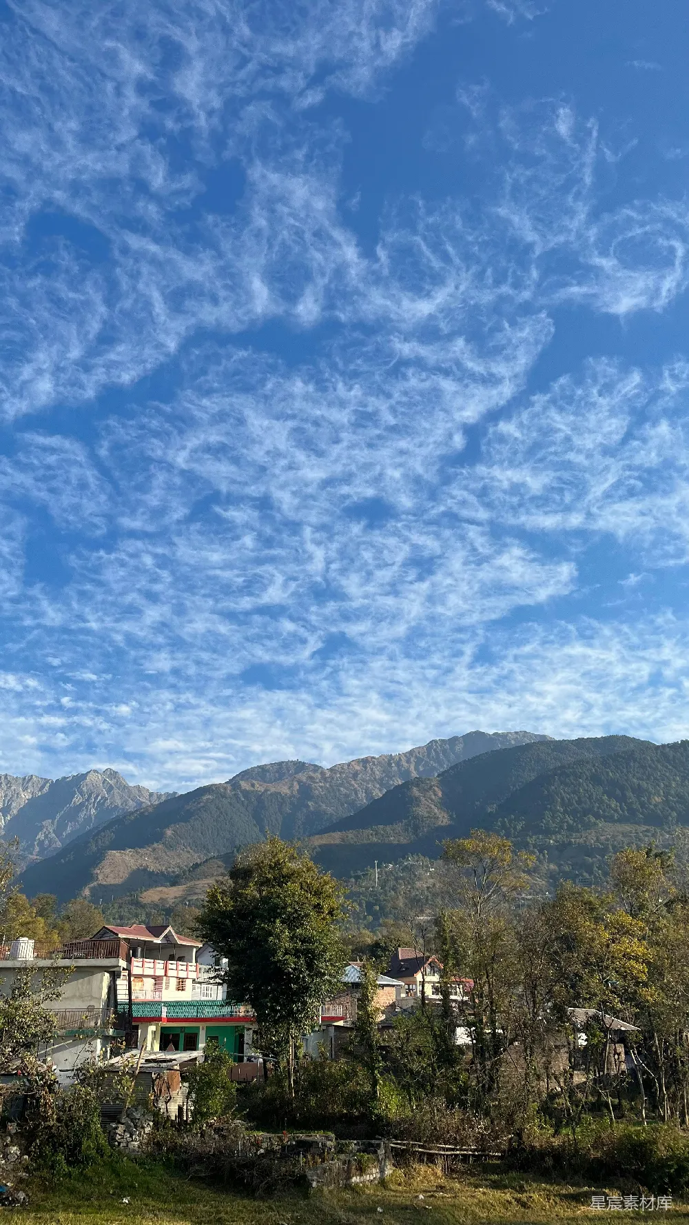 高清摄影 坐落在灰蒙蒙天空下的山峦间的房屋